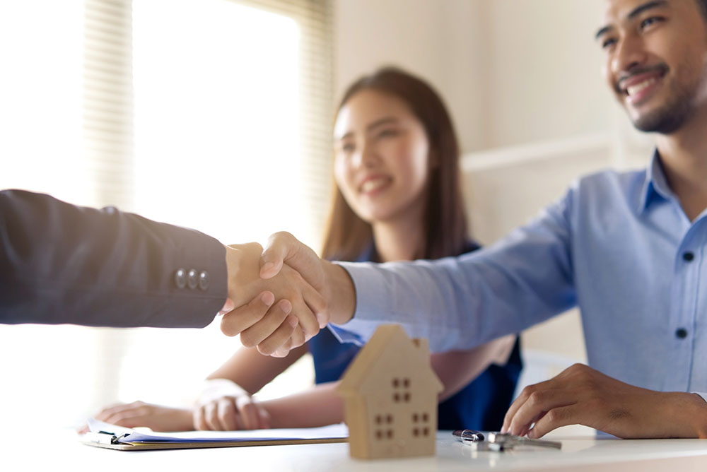 A house buyer shaking hands with a seller or real estate agent