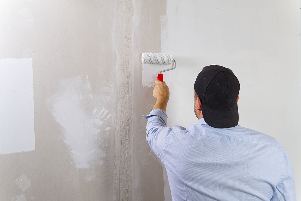 man painting drywall